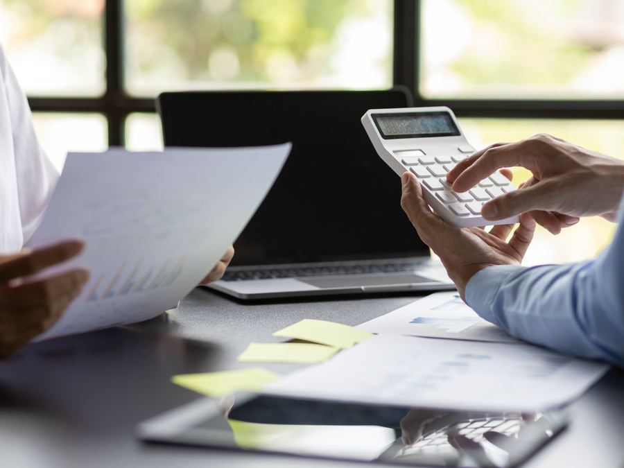 Asesor calculando junto a un cliente con documentos